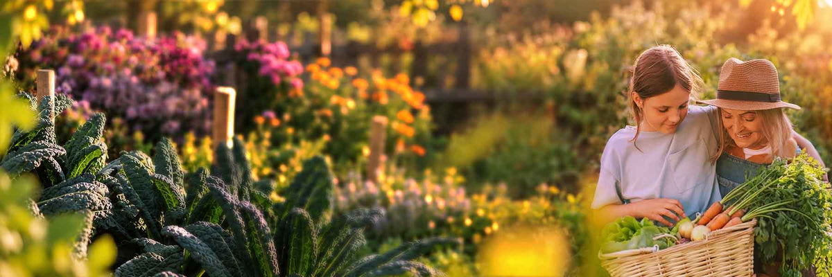 A woman and a child wearing a wide-brim hat are harvesting fresh green vegetables from a wicker basket in a sunny, colorful garden.