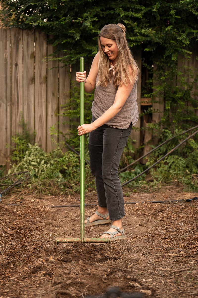 Woman using broadfork in the garden to till soil