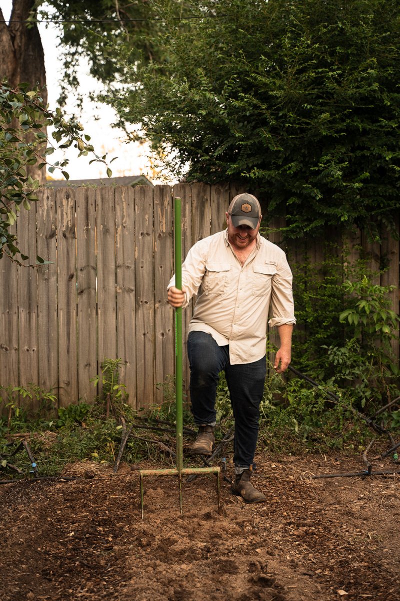Man using broadfork to till soil