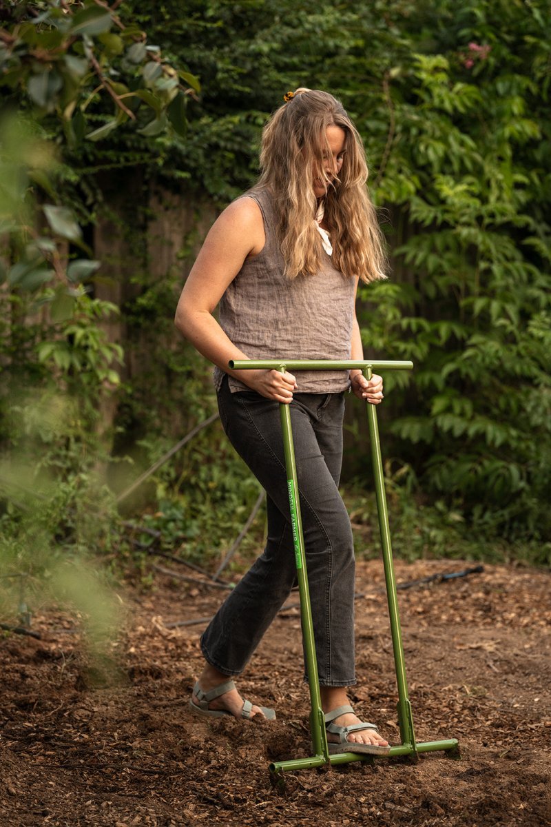Woman using a broadfork to till soil