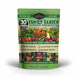 A green stand-up pouch of Survival Garden Seeds '30 Family Garden Heirloom Seed Varieties' seed packets, featuring colorful illustrations of fresh vegetables and herbs on the front, set against a plain white background with a soft shadow.