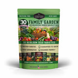 A green stand-up pouch of Survival Garden Seeds '30 Family Garden Heirloom Seed Varieties' seed packets, featuring colorful illustrations of fresh vegetables and herbs on the front, set against a plain white background with a soft shadow.