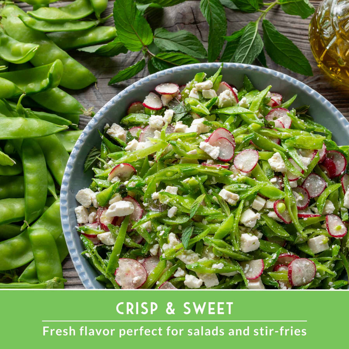 Bowl of green salad with radishes and feta cheese, surrounded by fresh green beans on a wooden surface.