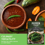 Bowl of red sauce with peppers and a package of Pepper Serrano seeds on a wooden surface.