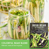 Jar of bush bean blend with a seed packet labeled 'Survival Garden Seeds' on a wooden surface.